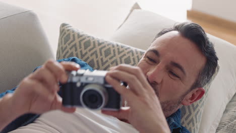happy couple taking photo together using camera having fun at home on sofa playfully enjoying romantic relationship
