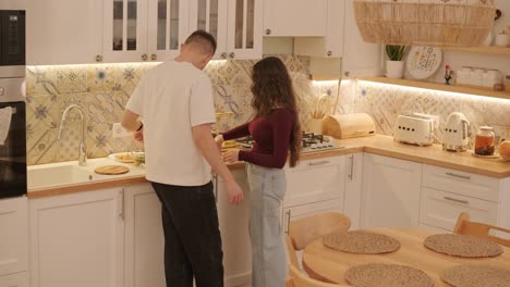 una pareja enamorada haciendo un sándwich en la cocina de la sala de estar