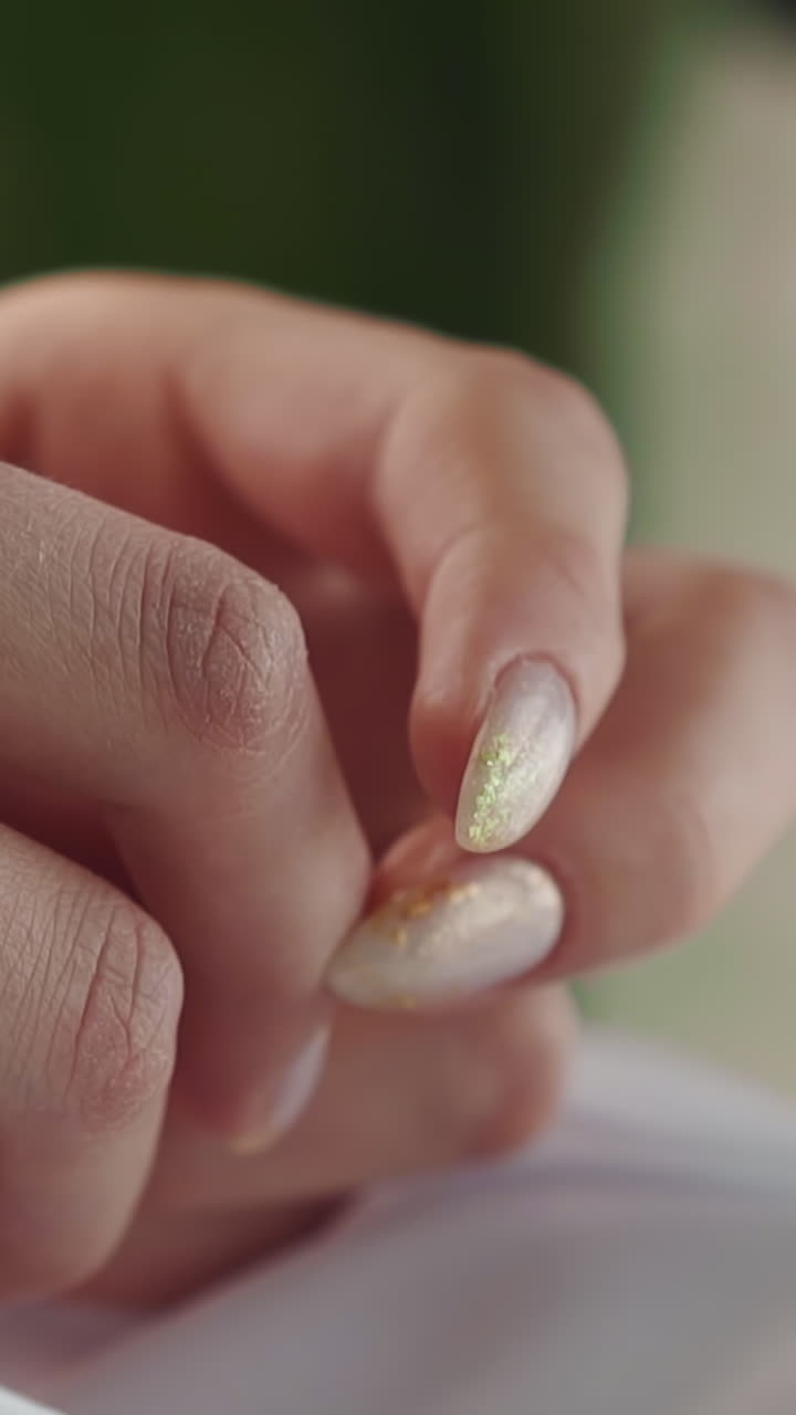 Woman with shiny manicure taps elegant fingers sitting in light room closeup. Beauty and glamour lifestyle. Long stylish nails making service