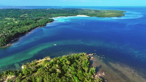 turquoise water of turtle bay entrance with sandy beach in philippines on puerto princesa south road. idyllic tropical landscape view in asia. aerial wide shot.