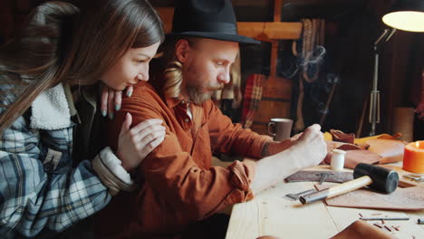 Man-Smoking-and-Crafting-Leather-in-Workshop-with-Wife