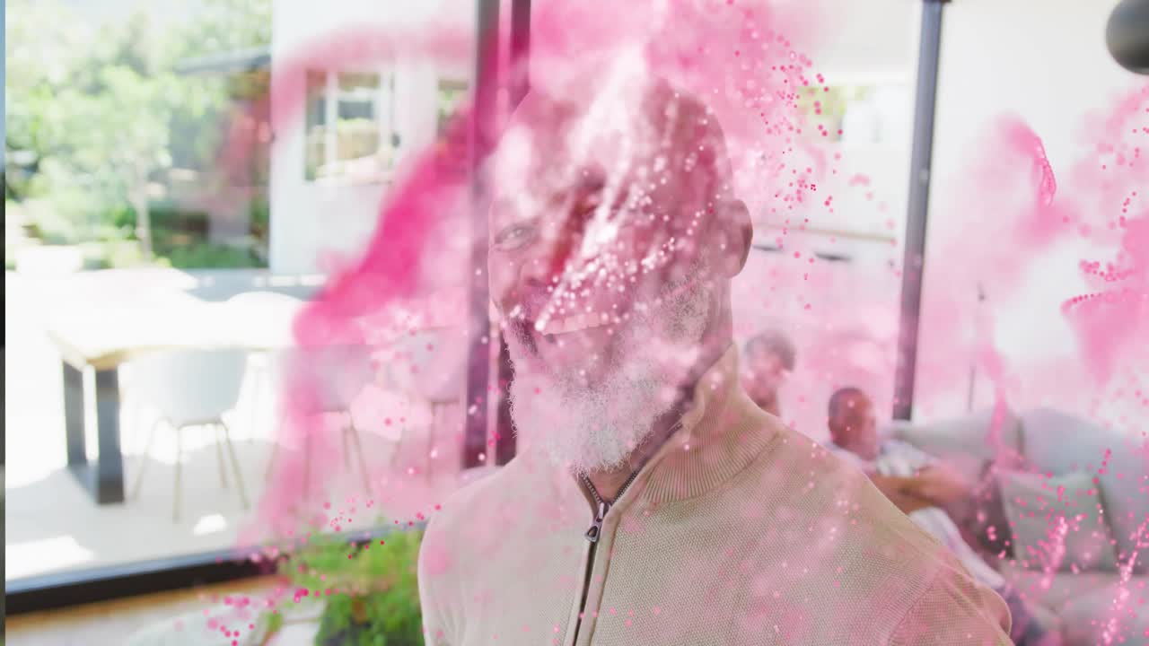 Sovrapposizione di particelle rosa che attraversano la cornice, rivelando un uomo anziano che sorride a una porta a vetri in un ambiente tecnologico.