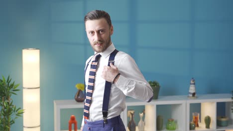 elegant and handsome man dressed in style in modern house looking at camera and smiling.