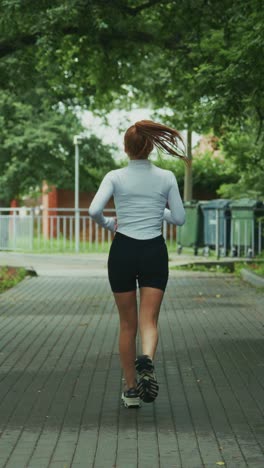 a determined jogger makes her way through a tree-lined pathway, embracing the freedom of outdoor exercise and the joy of staying fit and active amid a scenic backdrop
