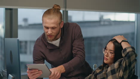 Business-couple-watching-monitor-at-workplace-closeup.-Chief-pointing-computer