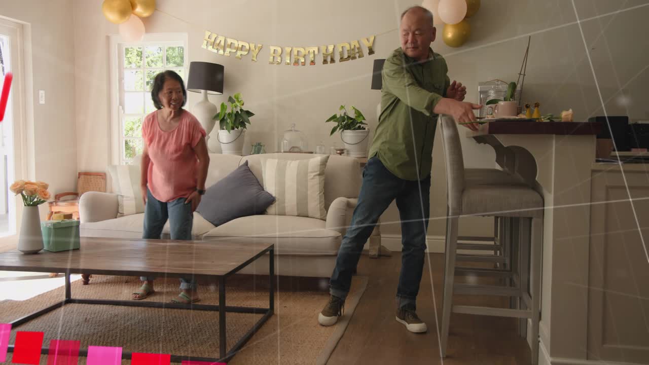 Casal preparando um aniversário na sala de estar, colocando um copo e fazendo com que um gráfico rosa suba sobre o casal