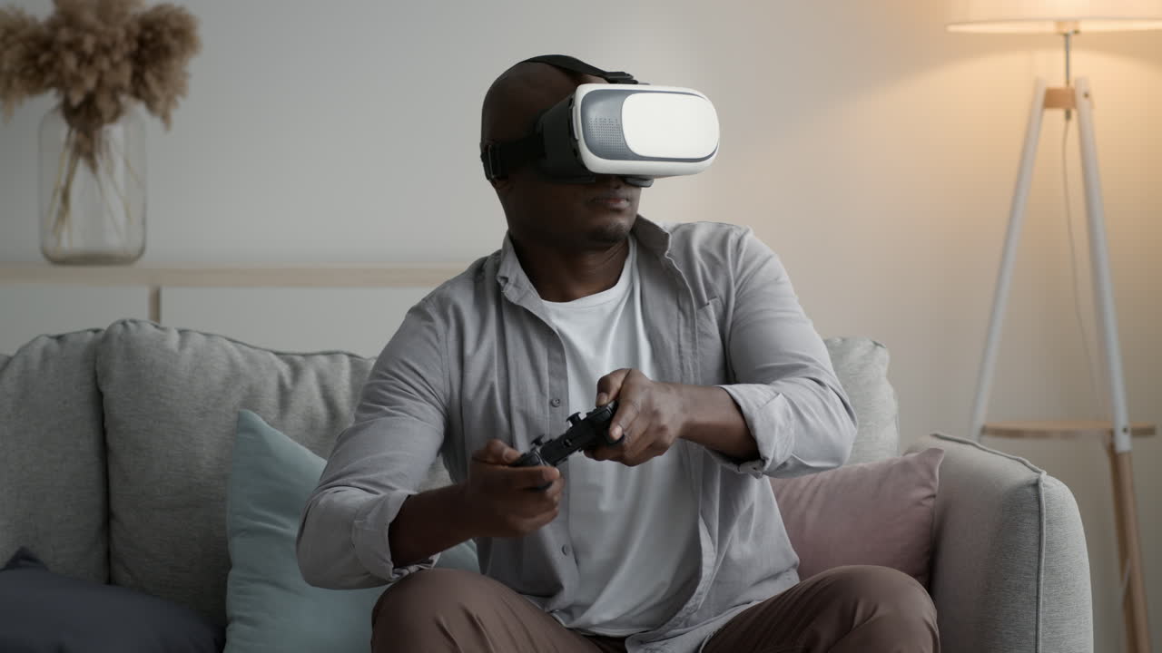 Uomo che gioca a un videogioco VR sul divano.