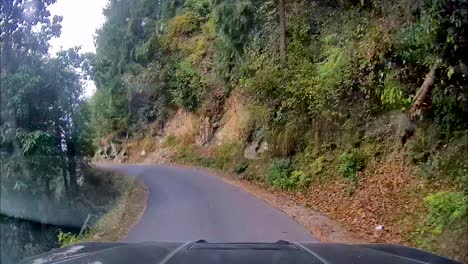 view through dash camera showing suv driving through narrow, dangerous and curved mountainous roads