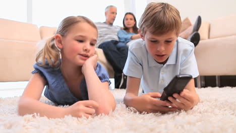 siblings laughing while watching the television