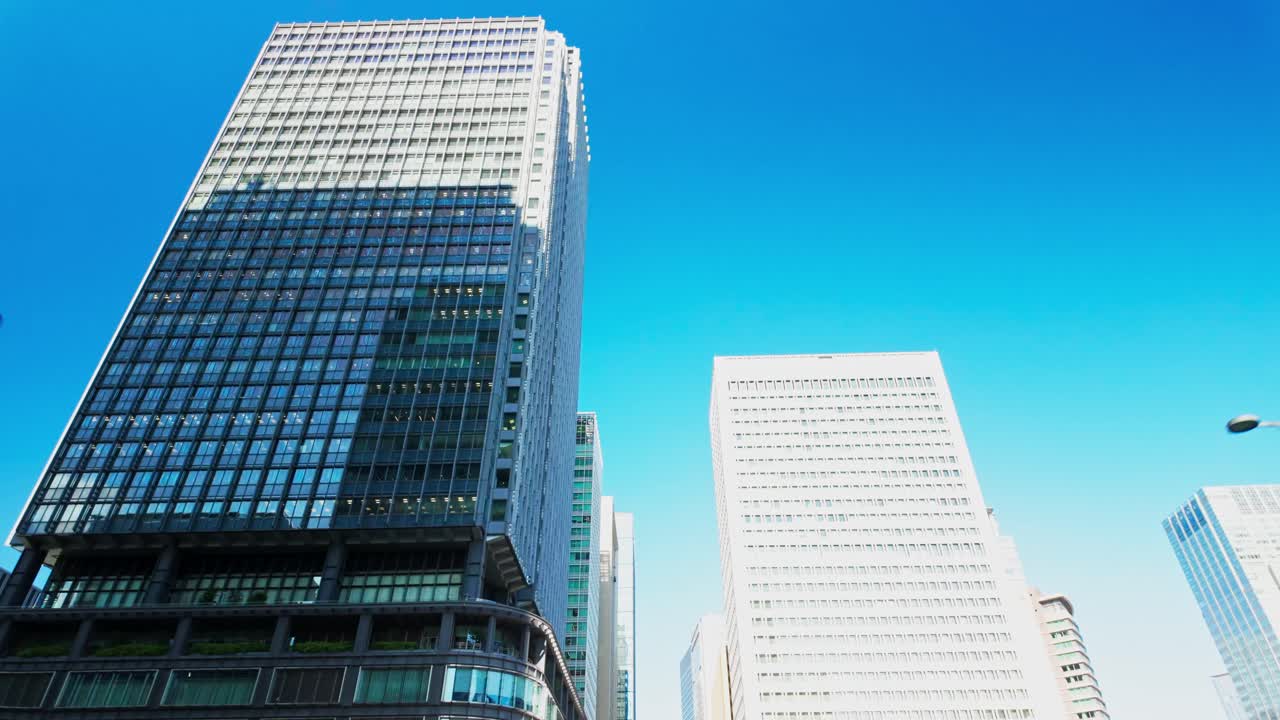 A view looking up captures Marunouchi’s towering skyscrapers rising into the sky in Tokyo Japan