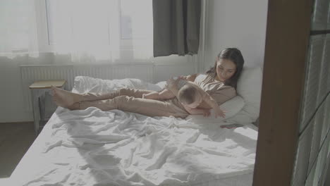 편안한 집에서 침대에 누워있는 엄마와 귀여운 아기