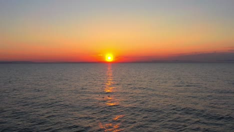 Statische-Luftaufnahme-Von-Möwen,-Die-In-Der-Gelben-Spiegelung-Des-Sonnenuntergangs-In-Der-Nordsee-Am-Findhorn-Beach-In-Schottland-Stehen