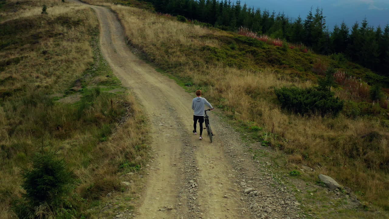 산을 타고 자전거를 타는 사람 바위 길이 자전거를 움직이는 봄 풀 녹색 나무
