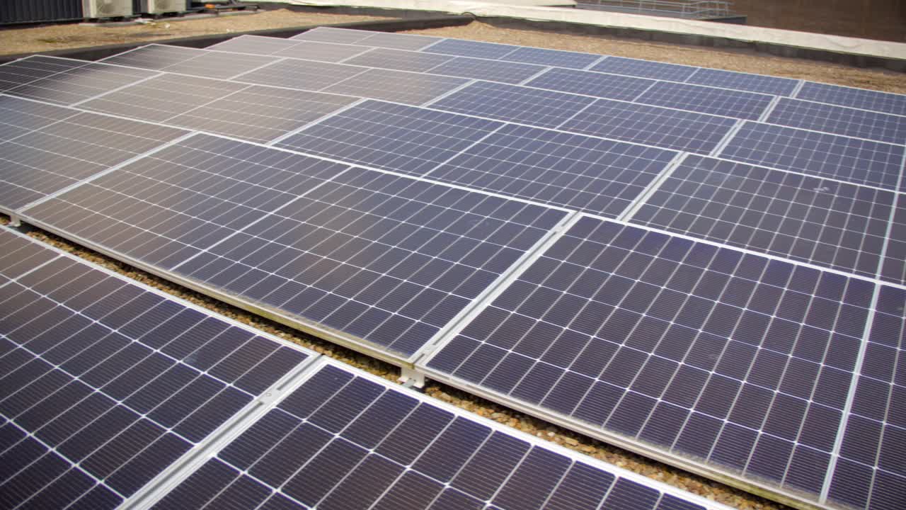 Slow revealing video of a solar panel array filmed on a bright and sunny day. Produced in 4K, 30FPS and with Rec709 color