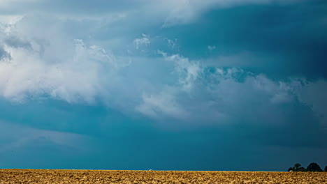 el lapso de tiempo de las nubes dramáticas brillan con luz azul sobre vastas tierras de cultivo
