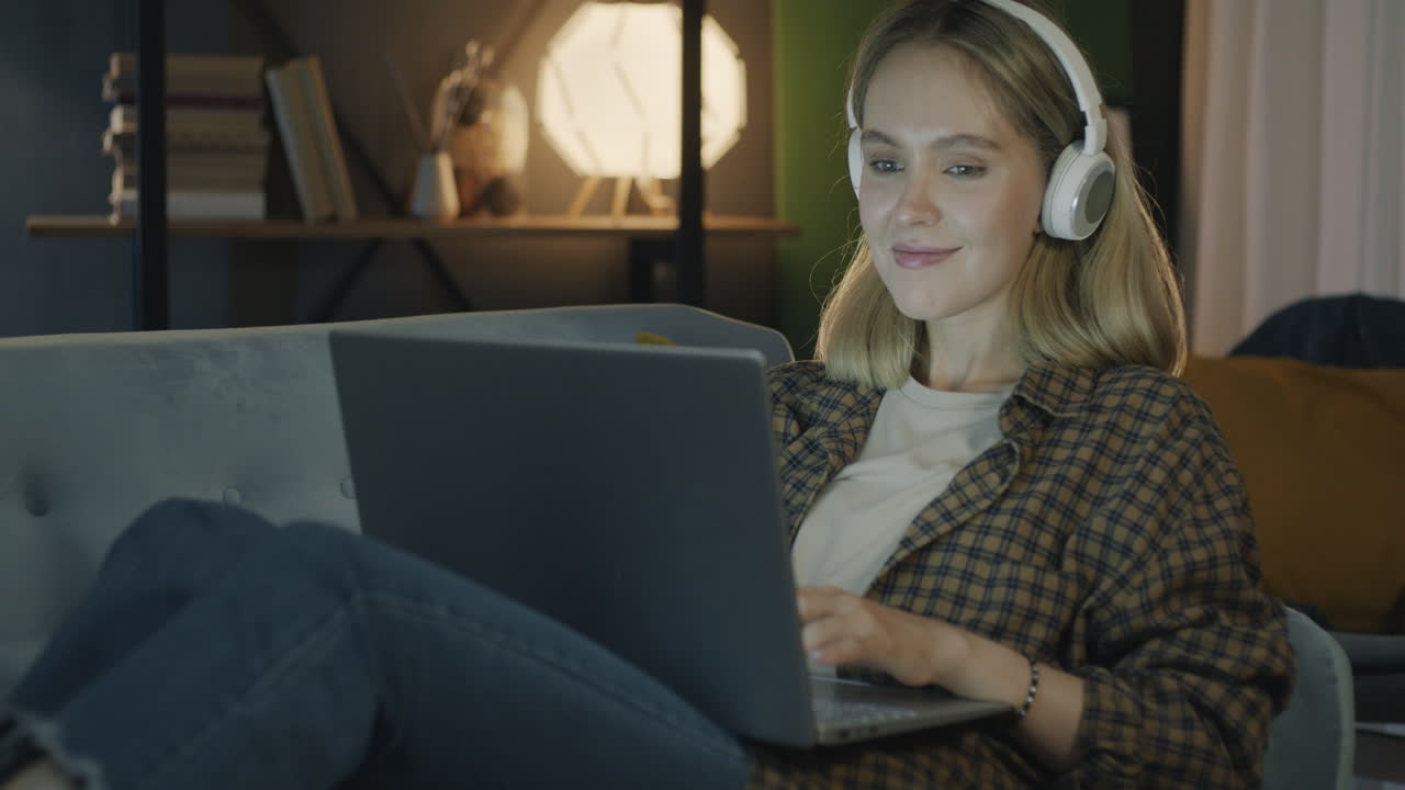 mujer trabajando en una computadora portátil en casa por la noche