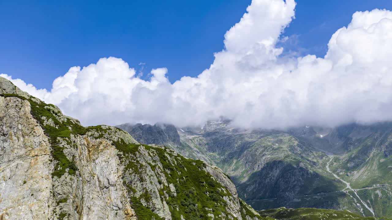 Skyer der strømmer over de grønne alpetoppe ved Susten Pass i de schweiziske alper, Schweiz. Hyperlapse, luftdrone FPV, tekstplads