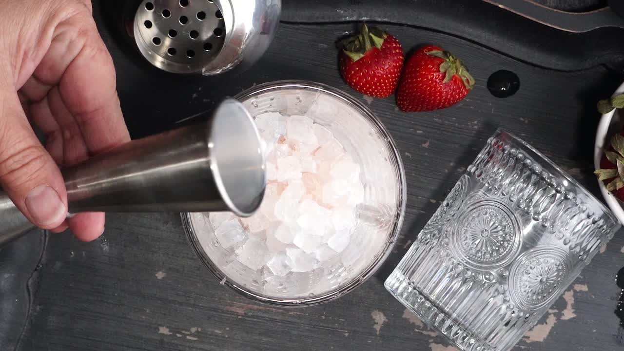 Pink cocktail drink with strawberry liqueur, vanilla vodka and cream. Party drink with strawberries. Fruit cocktail with fresh strawberries as a garnish. Cold and refreshing