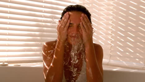 Mujer-Salpicándose-Con-Agua-En-El-Baño