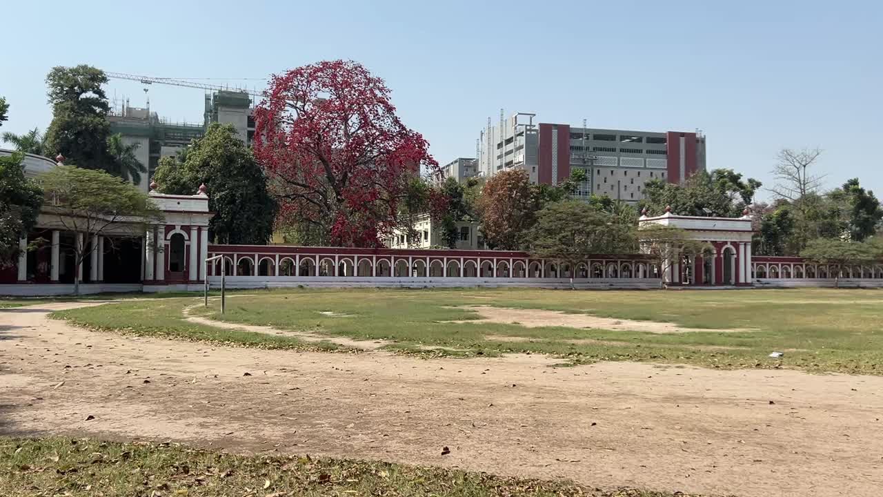 Pan shot of Patna University on weekend afternoon with long sports field in front.