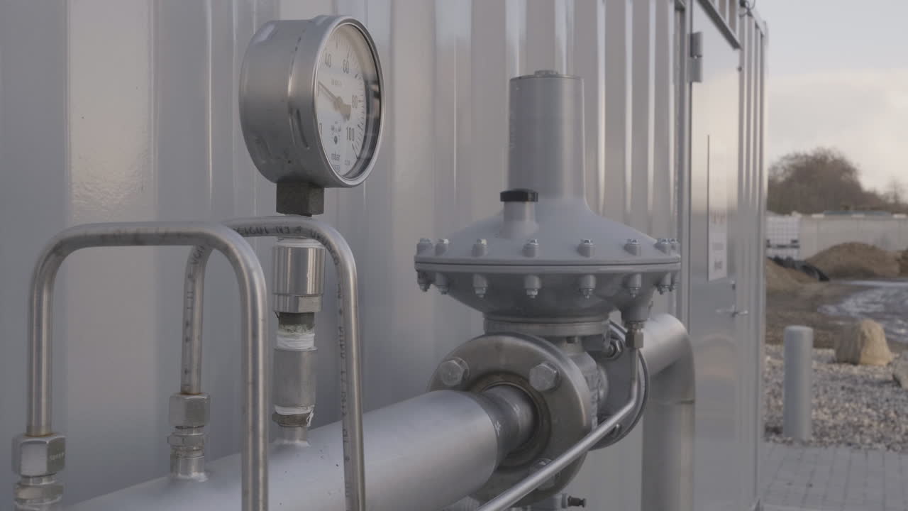 Detailed view of a modern biogas installation in rural Denmark, showing tanks, pipes, and clean energy infrastructure producing renewable gas from organic waste
