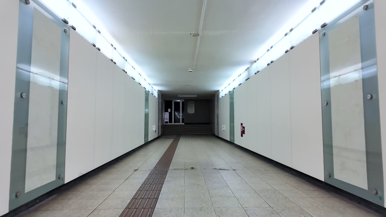 POV Brightly illuminated empty tunnel underpass with modern architecture and tiled flooring.