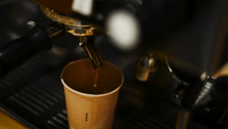 un primer plano en ángulo alto deslizándose alrededor de una máquina de espresso sirviendo café caliente en una taza de espresso