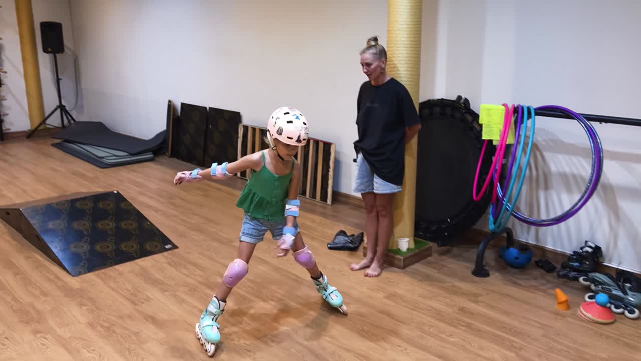 Dívka se učí jezdit na kolečkových bruslích ve fitness centru