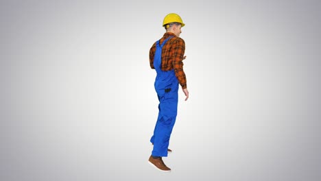 joven trabajador de la construcción con sombrero duro bailando hip-hop en el fondo del gradiente