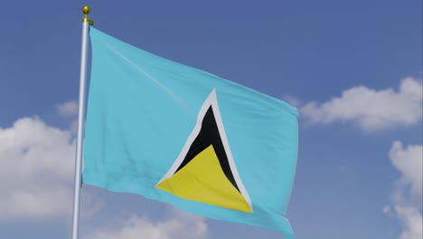 flag of saint lucia moving in the wind with a clear blue sky in the background, clouds slowly moving, flagpole, slow motion