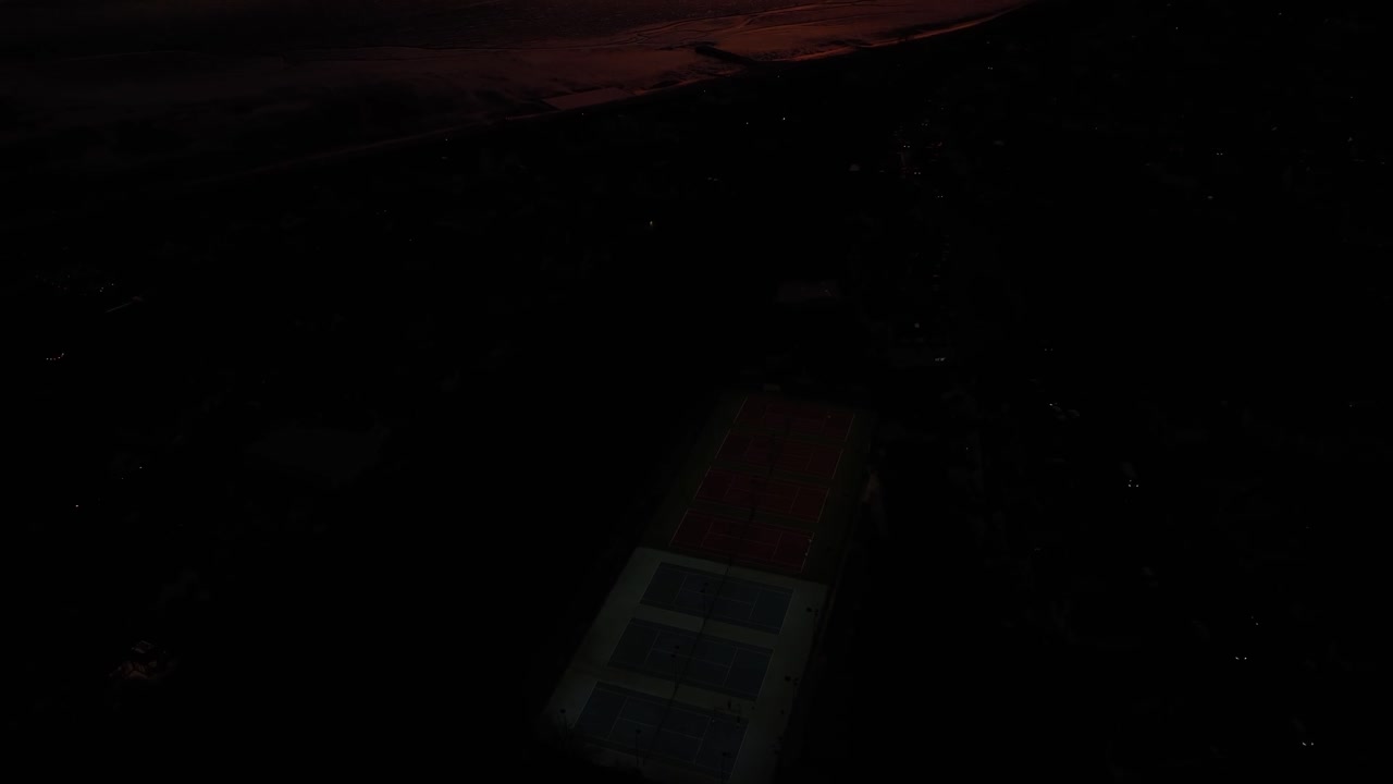 drone al anochecer disparado durante la épica puesta de sol comienza baja y oscura y se levanta para revelar los colores épicos de la puesta de sol sobre la arena y el mar