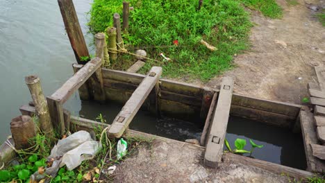 Compuerta-De-Esclusa,-El-Agua-Se-Transporta-Al-Lugar-Donde-Se-Lleva-A-Cabo-La-Piscicultura,-Una-Compuerta-Corredera-U-Otro-Dispositivo-Para-Controlar-El-Flujo-De-Agua,-Especialmente-Uno-En-Una-Compuerta-De-Esclusa,-Tiro-Panorámico-Completo