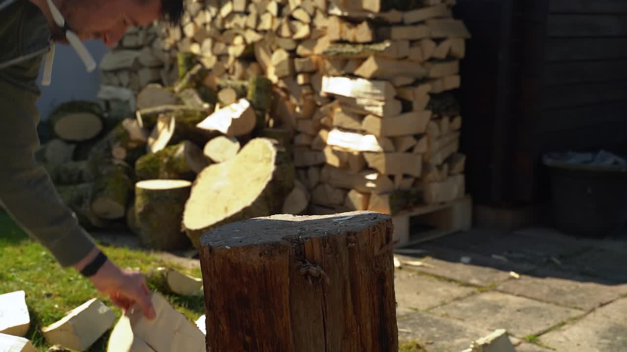Chopping firewood with an axe and splitting block in slow motion.