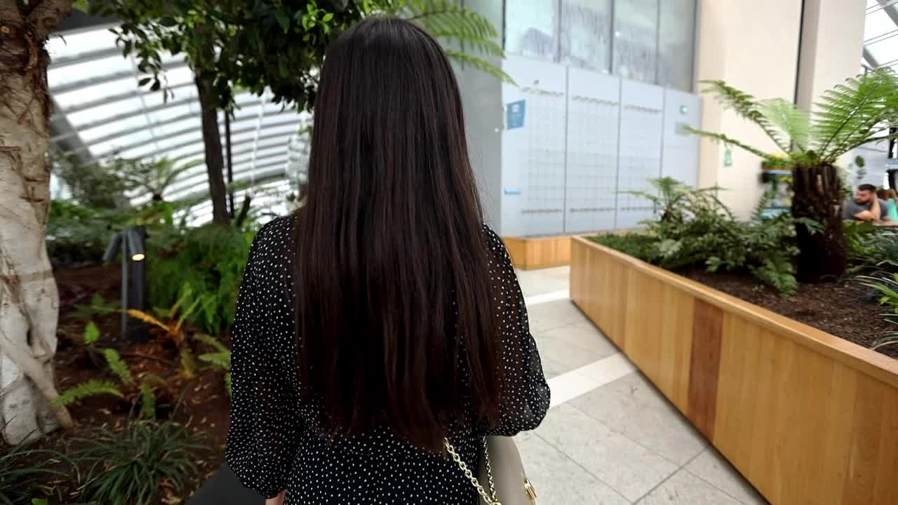 실내 위치에서 '나를 따라와' 제스처를 만드는 세련된 매력적인 소녀