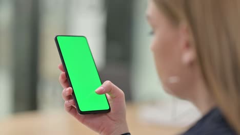 rear view of businesswoman holding smartphone with chroma screen