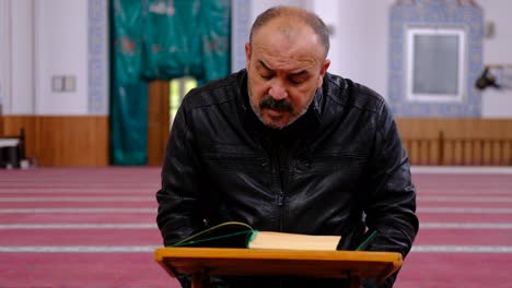 Hombre-De-Mediana-Edad-Leyendo-El-Corán-En-La-Mezquita