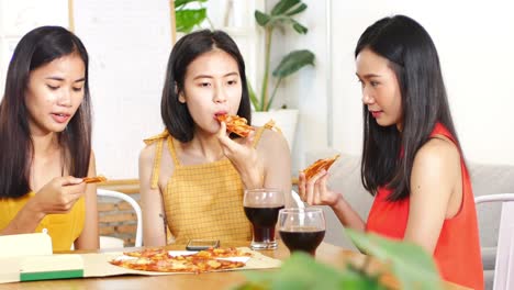 젊은 아름다운 아시아 여성 그룹이 피자를 먹고 레스토랑에서 그들의 일반적인 행복한 주제에 대해 이야기합니다.