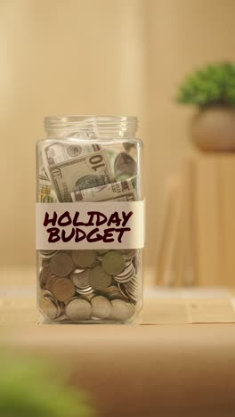 vertical video of person saving money for holiday budget
