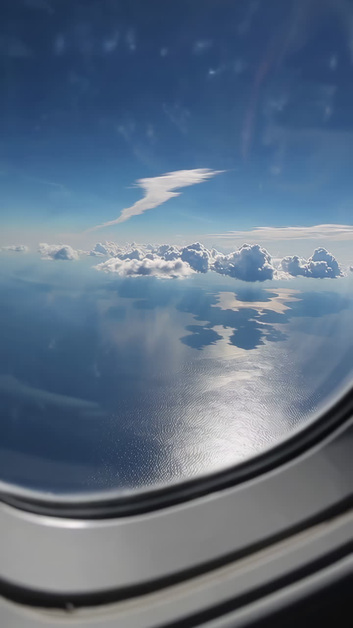 Aerial View of Clouds and Ocean from Airplane Window