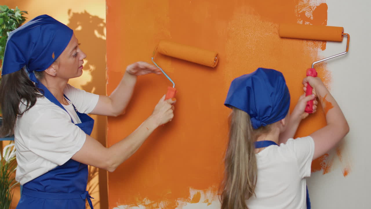 Mother and Daughter Painting Wall Together