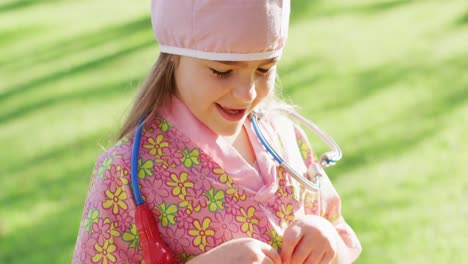 Video-of-happy-caucasian-girl-in-nurse-costume-holding-halloween-trick-or-treat-basket-in-garden