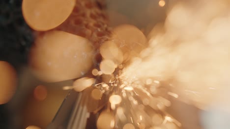sparks erupt in slow motion as metal grinds against metal in an abstract close up moment