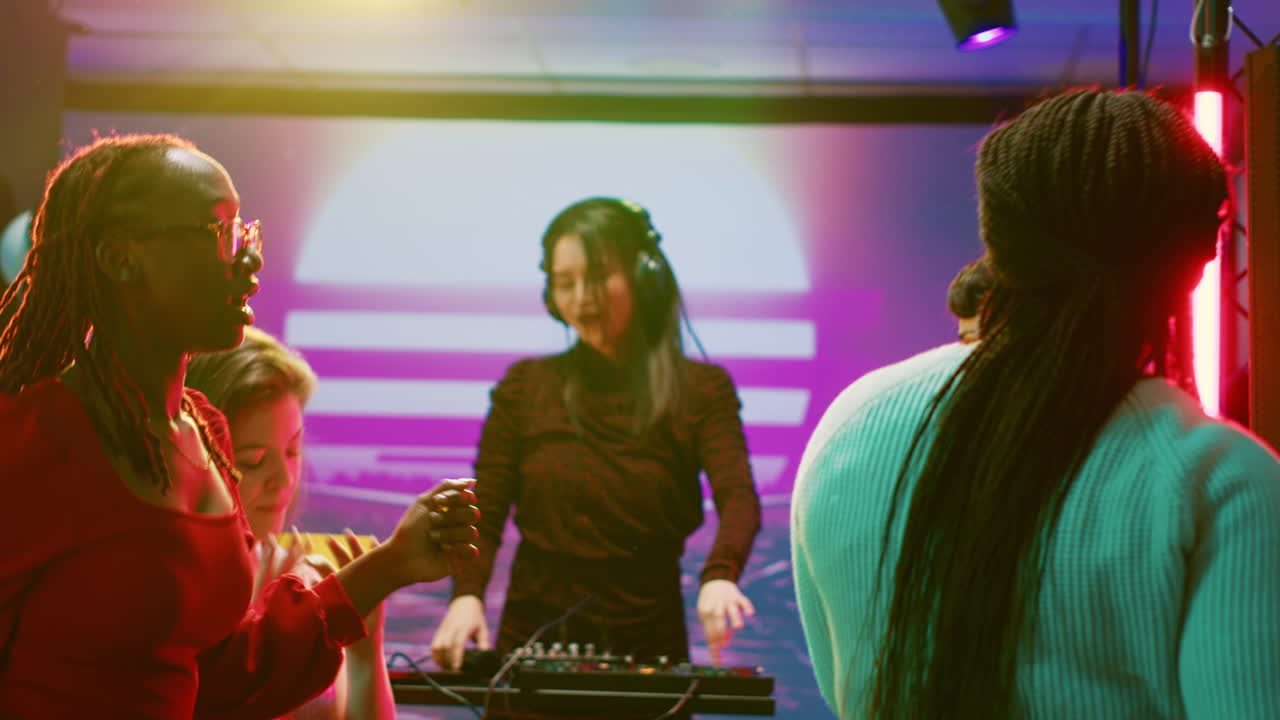 People dancing at a club party with a DJ