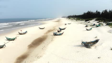 flying over fishing boats at trung thanh beach vietnam, aerial