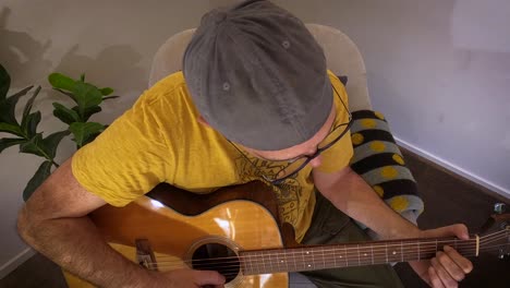 a happy mature man smiles and interacts with the audience while playing the guitar