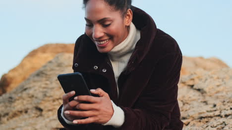 una chica afroamericana usando un teléfono móvil.