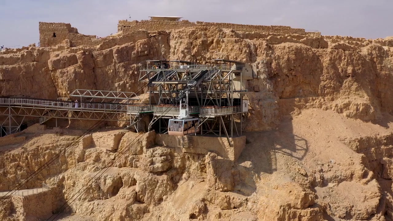 Masada Kalesi'nin Sarp Kayalıklarına İnşa Edilmiş Modern Teleferik İstasyonunu ve Üst Terminale Varan Bir Yolcu Kabinini Yakalayan Yüksek Açılı Drone Çekimi