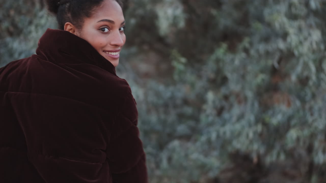 африканско-американская девушка кружится на открытом воздухе.