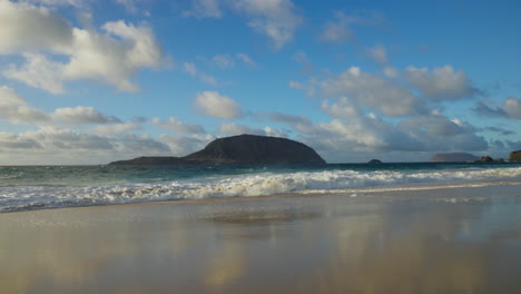 Beautiful-view-of-an-island-in-Lanzarote-with-a-few-clouds-in-the-sky-and-crashing-waves