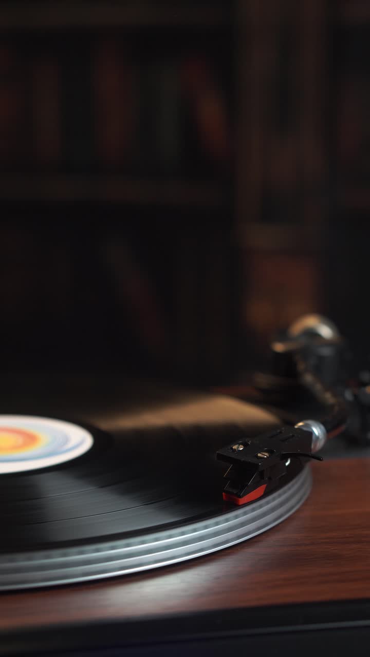 Vista verticale, avvio della riproduzione di un disco in vinile audio vintage, primo piano.